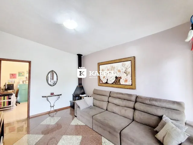 Sala de estar com sofá grande e lareira em ambiente claro.
