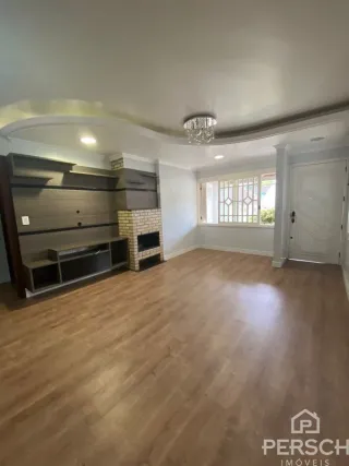 Sala de estar com piso de madeira e estantes embutidas.