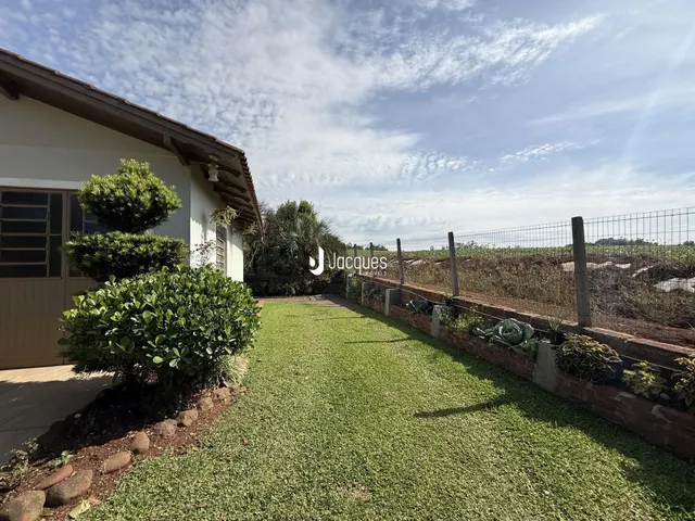 Vista da fachada de uma casa com jardim e cerca em Lajeado, Brasil.