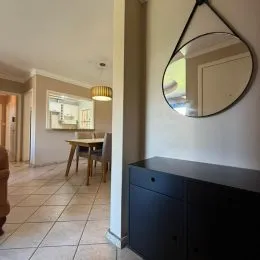 Hall de entrada com piso de cerâmica e espelho na parede.