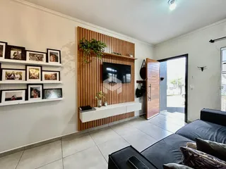 Sala de estar com painel de madeira e estantes decorativas.