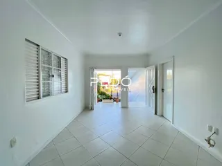 Hall de entrada com piso de cerâmica e paredes brancas.