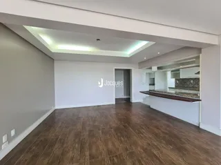 Sala de estar com piso de madeira e teto abobadado.