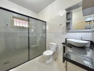 Banheiro moderno com box de vidro e piso cerâmico em Lajeado.