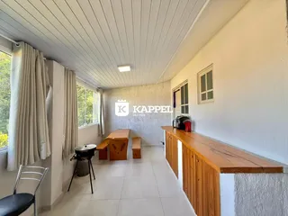 Foto de um ambiente interno com bancada de madeira e piso claro.