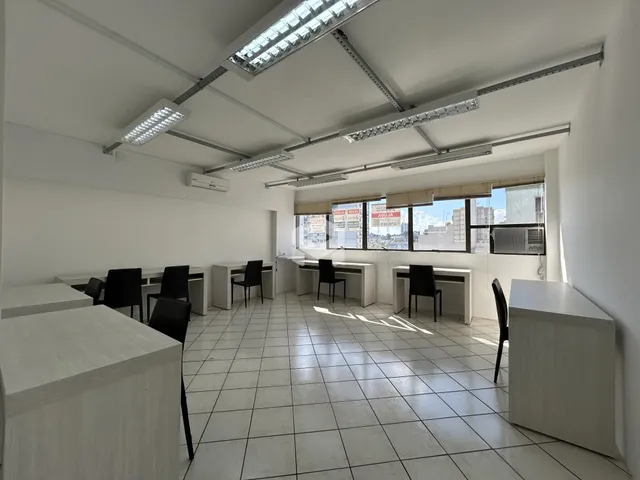 Ambiente interno de um escritório com piso de cerâmica e grandes janelas.