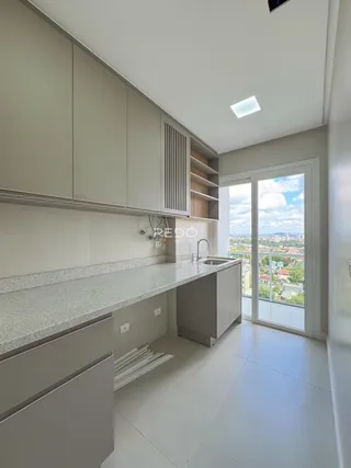 Cozinha moderna com armários cinzas e bancada clara.