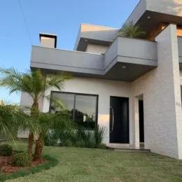 Fachada moderna de uma residência em Lajeado, Brasil, com paisagismo verde.