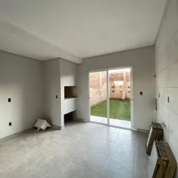 Foto de um ambiente interno com piso de cerâmica e porta de vidro que dá acesso a um jardim.
