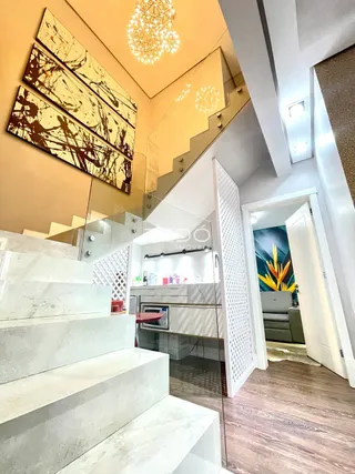 Vista de uma escadaria moderna com acabamentos em mármore e vidro.