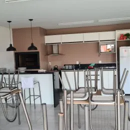 Foto de uma cozinha com armários brancos e bancos de balcão.