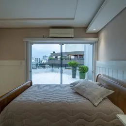 Quarto com cama e janela de vidro.