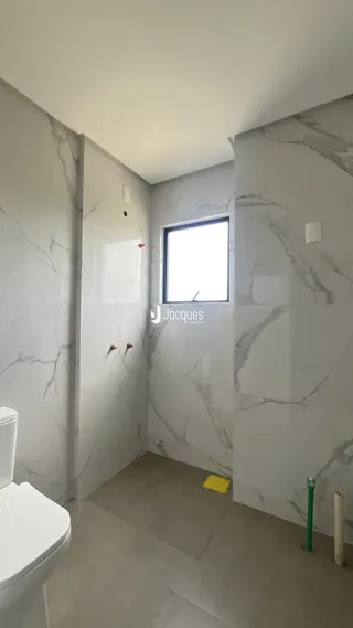 Foto de um banheiro com paredes em mármore branco.