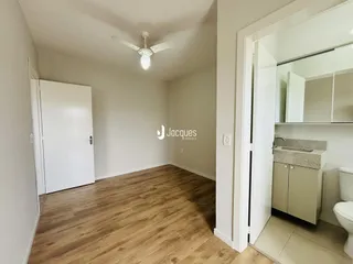Ambiente interno com piso de madeira e paredes brancas.