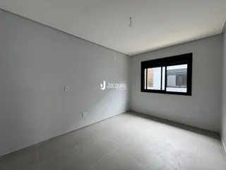 Ambiente interno de uma sala com piso de cerâmica e paredes brancas.