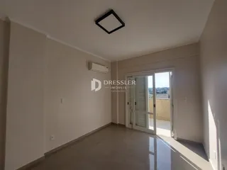 Interior de um ambiente com piso claro e paredes brancas.