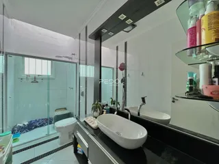 Foto de um banheiro moderno com box de vidro e bancada de mármore.