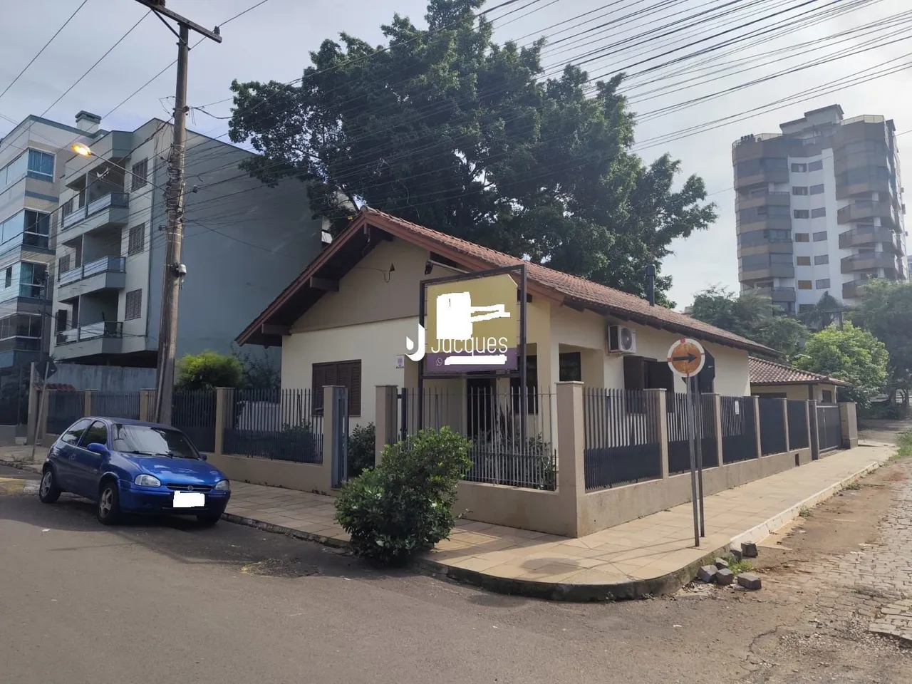 Fachada de uma residência em Lajeado, Brasil, com cerca e paisagismo frontal.