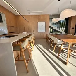 Foto de uma cozinha com bancada de madeira e cadeiras.