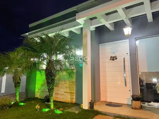 Fachada de uma residência em Lajeado, Brasil, com jardim e palmeiras.