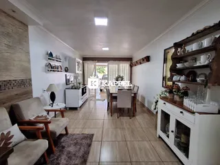 Sala de estar com sofá e área de jantar em um imóvel residencial.