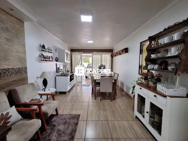 Sala de estar com sofá e área de jantar em um imóvel residencial.