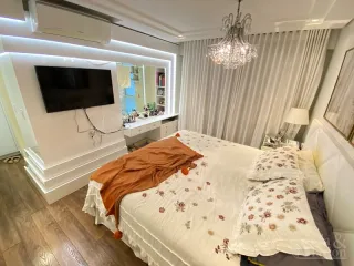 Quarto com cama de casal e piso de madeira clara.