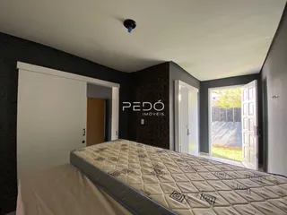 Quarto com cama grande e paredes cinzas na residência.