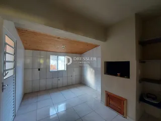 Interior de uma sala com piso de cerâmica e teto de madeira.