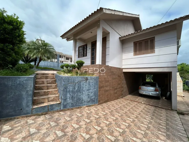 Fachada de uma residência em Lajeado, Brasil, com escadaria e área externa pavimentada.