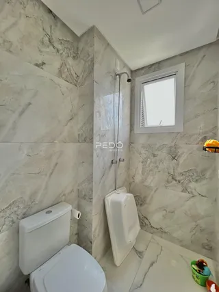 A foto mostra o interior de um banheiro com revestimento em mármore.