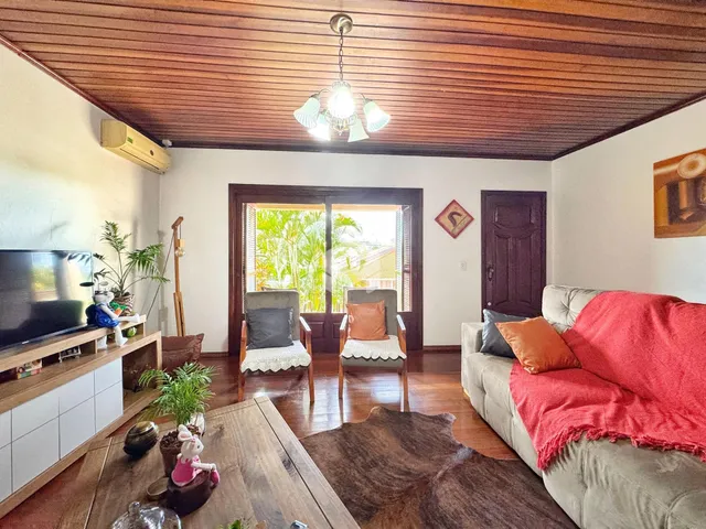 Sala de estar com piso de madeira e porta de vidro abrindo para o exterior.