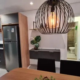 Foto de um lustre escultural pendurado no teto de um ambiente interno.
