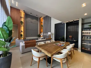 Sala de estar e jantar com mesa de madeira e estantes modernas.