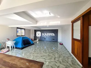 Ambiente interno com um toldo azul no centro de uma sala com piso de cerâmica.