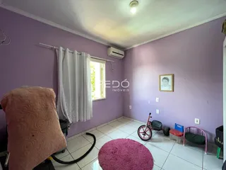 A sala de um imóvel em Lajeado, Brasil, com paredes roxas e piso de cerâmica.