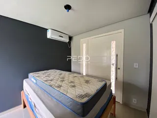 Quarto com cama e ar condicionado instalado na parede.