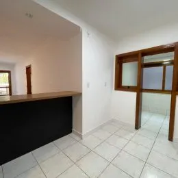 Foto de um corredor interno com piso de cerâmica branca e paredes brancas.