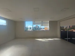 Ambiente interno de uma sala ampla com piso de cerâmica clara.
