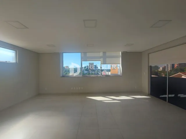 Ambiente interno de uma sala ampla com piso de cerâmica clara.
