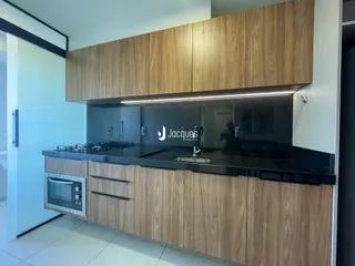 Cozinha moderna com armários de madeira e bancada preta.