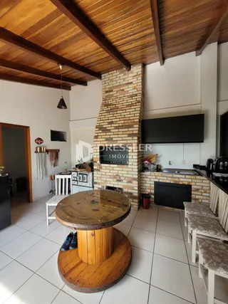 Ambiente interno com teto de madeira e parede de tijolos aparentes.