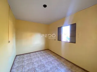 Corredor com piso de cerâmica e paredes amarelas.