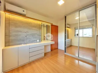 Sala de estar e cozinha com piso de madeira clara.