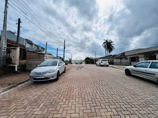 Vista da rua pavimentada em Lajeado, Brasil com veículos estacionados.