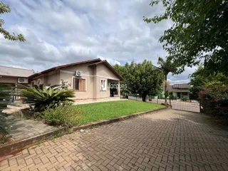 Fachada de uma casa em Lajeado, Brasil, com jardim e área pavimentada.