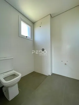 Foto de um banheiro interno com vaso sanitário branco e janela.