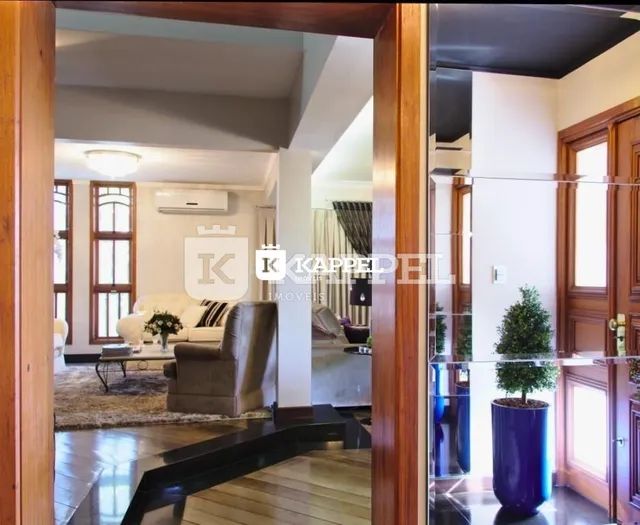 Vista interna de uma sala de estar com piso de madeira e sofá.