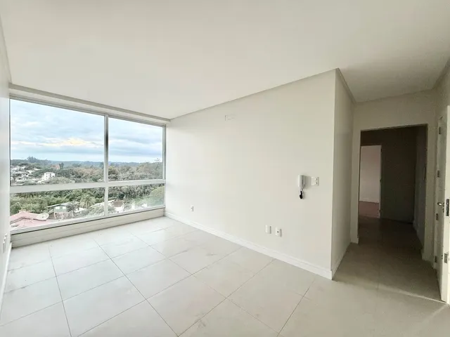 Sala de estar com grande janela que oferece uma vista da paisagem externa.