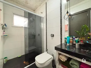 Foto de um banheiro com box de vidro e vaso sanitário em Lajeado.